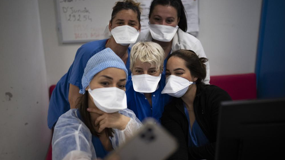 Hospital workers pose for a selfie together in the COVID-19 intensive care unit of the la Timone hospital in Marseille, southern France, on Saturday, Dec. 25, 2021.&nbsp;