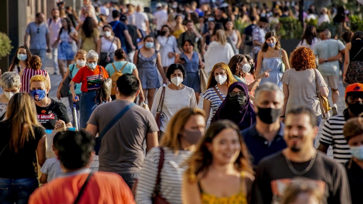 People wearing a face mask to protect against the spread of coronavirus walk along a street in downtown Barcelona