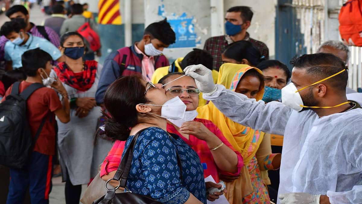 A healthcare worker collects swab sample of a passenger for Covid test, at Dadar railway station, in Mumbai on Jan 28, 2022.
&nbsp;