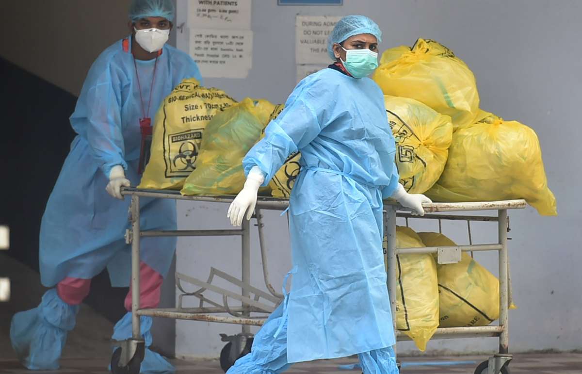 Kolkata: Workers carry waste from a State Government run Covid Hospital to dump