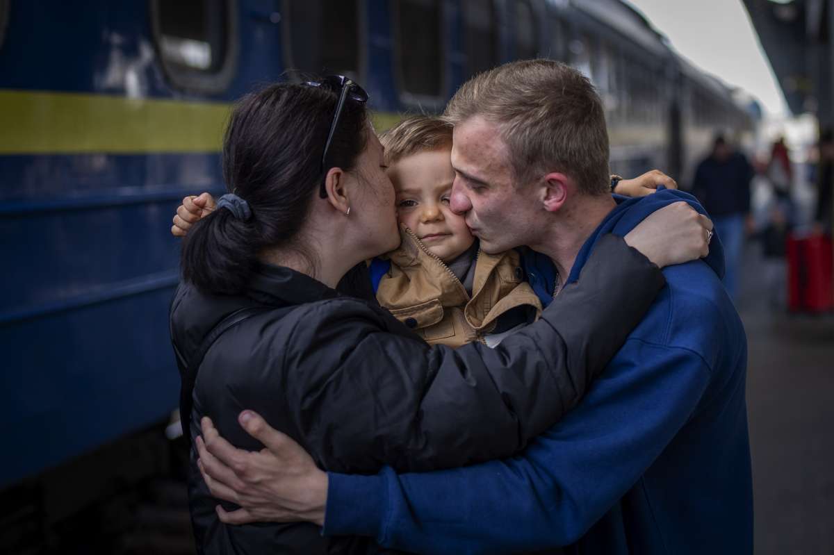 Oleksandr, 26 kisses his soon Egor, 2, and his wife Alyona, 26, as they meet at the train station after more than two months separated for the war in Kyiv, Ukraine on Saturday.&nbsp;
&nbsp;