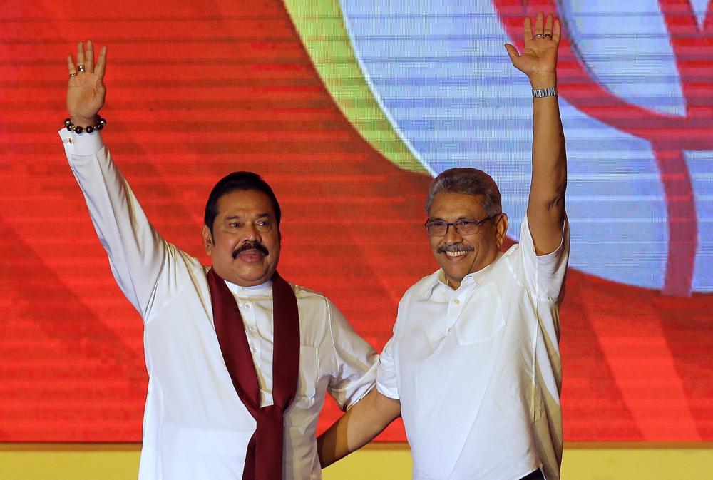 Mahinda Rajapaksa, left, and his brother Gotabaya Rajapaksa wave to supporters during a party convention held to announce the presidential candidacy in Colombo, Sri Lanka.&nbsp;