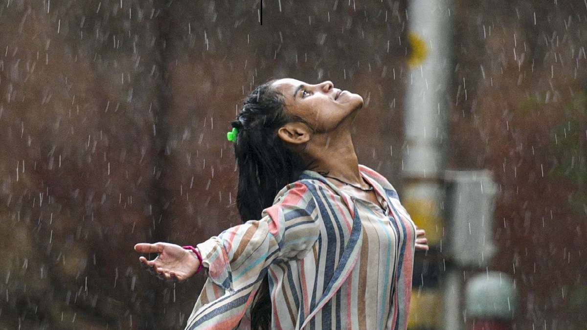 &nbsp;A young woman reacts during rains, in New Delhi