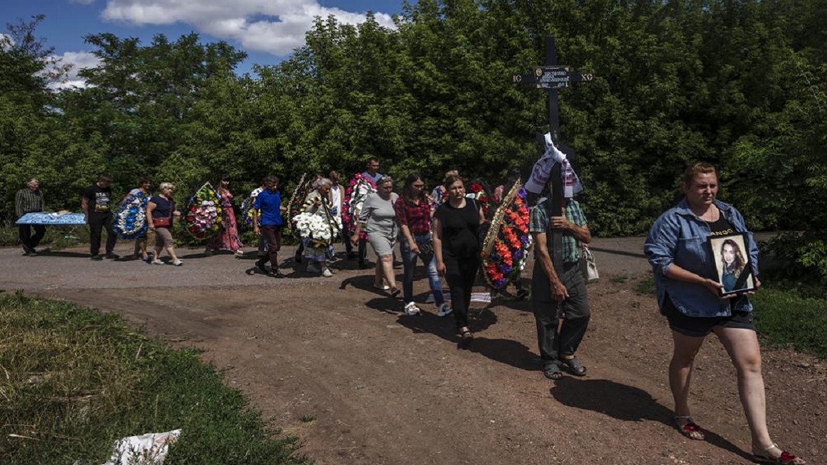 Family and friends of 35-year-old Anna Protsenko, who was killed in a Russian rocket attack, walk to a cemetery for her burial, during her funeral procession, on the outskirts of Pokrovsk, eastern Ukraine, Monday, July 18, 2022. 