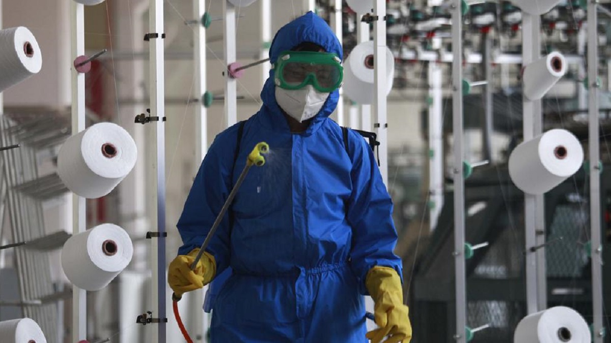 An employee of Songyo Knitwear Factory in Songyo district disinfects the work floor in Pyongyang, North Korea