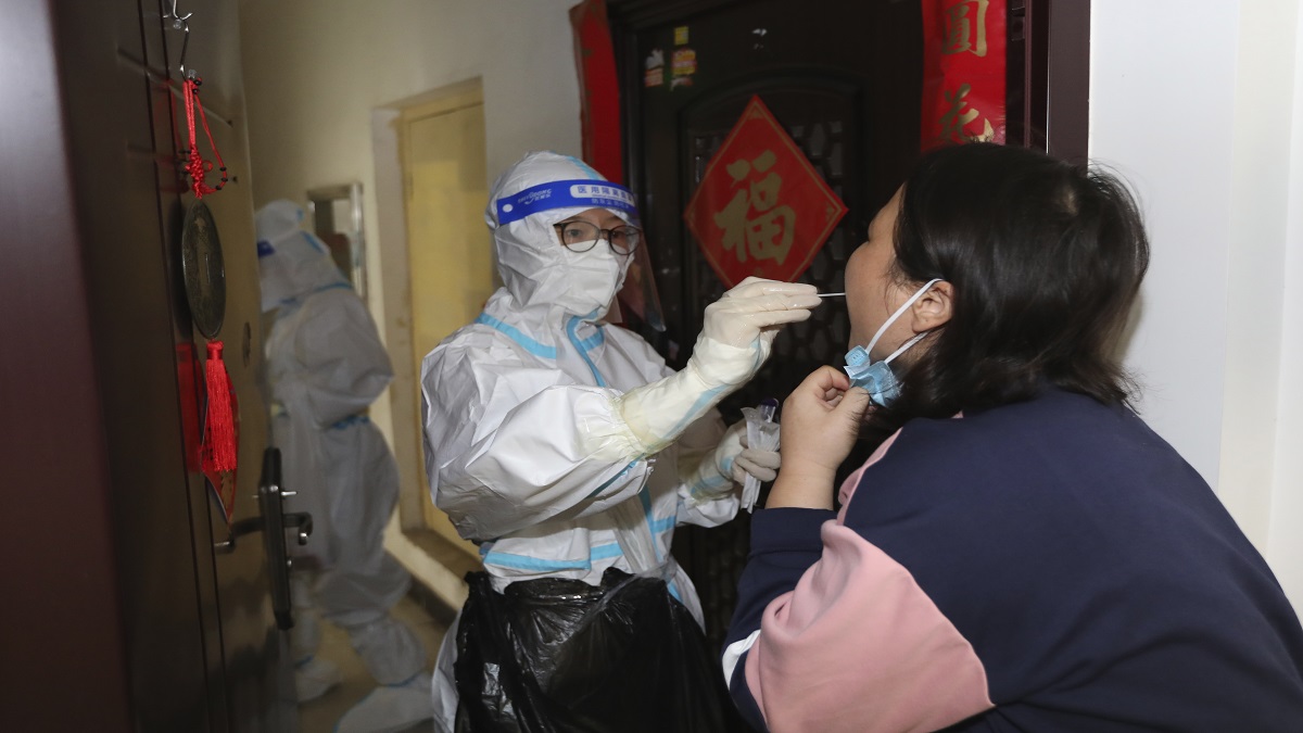 
A medical worker takes swab sample from a residents during a door-to-door Covid-19 screening in Zhengzhou in central China's Henan province. (File Photo)