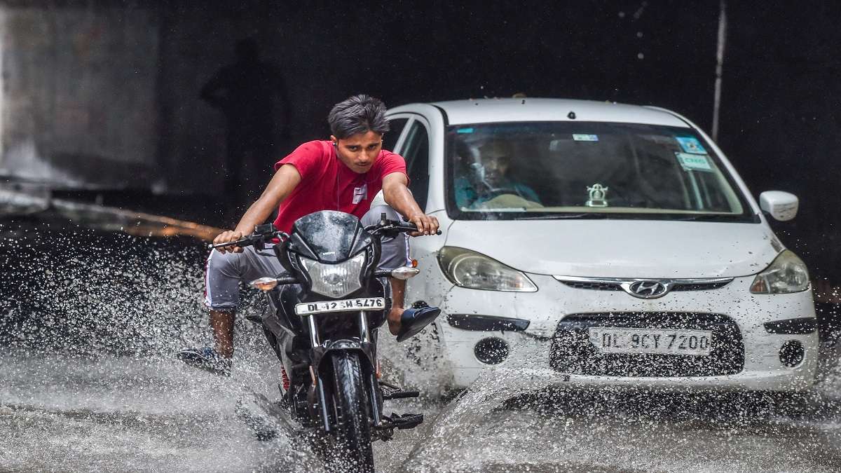 People drive through waterlogged road after monsoon rains in New Delhi