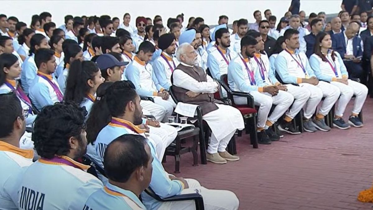 Prime Minister Narendra Modi sitting with India's Asian Games contingent.