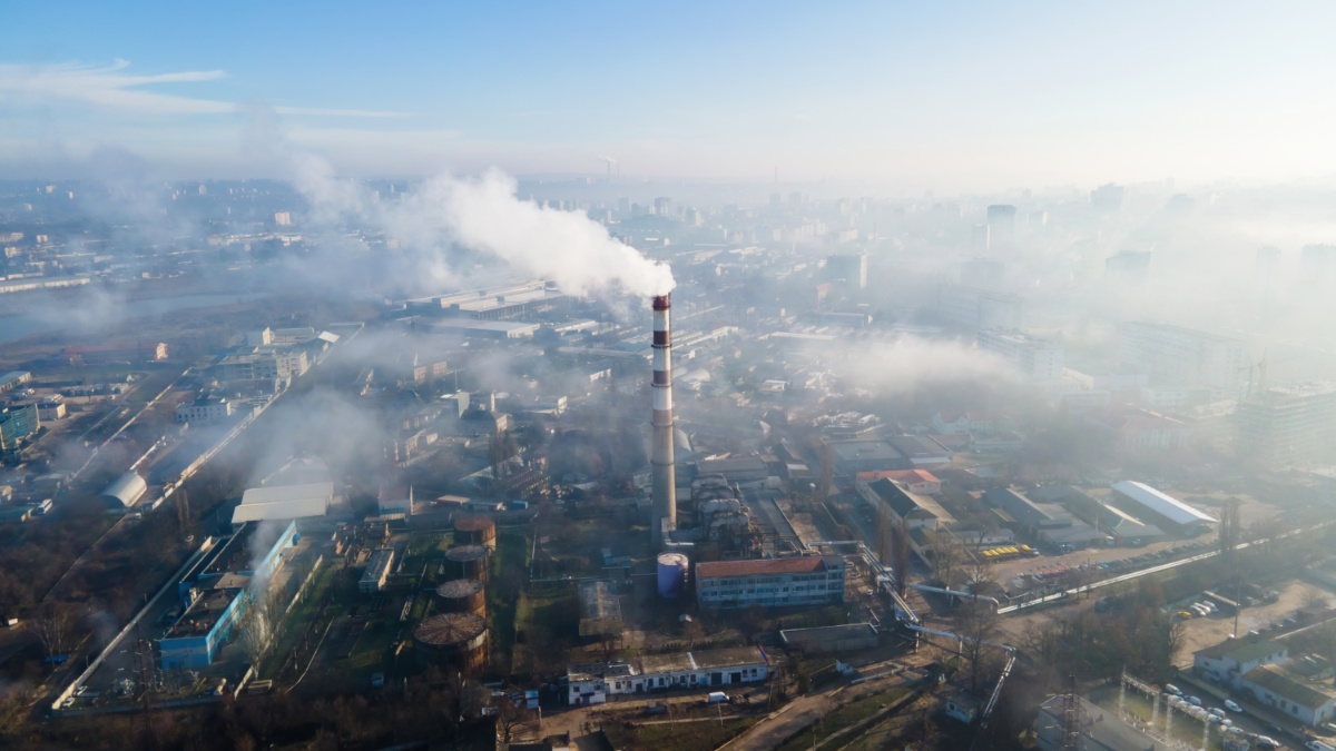Aerial drone view of a thermal station with smoke coming out of the tube.