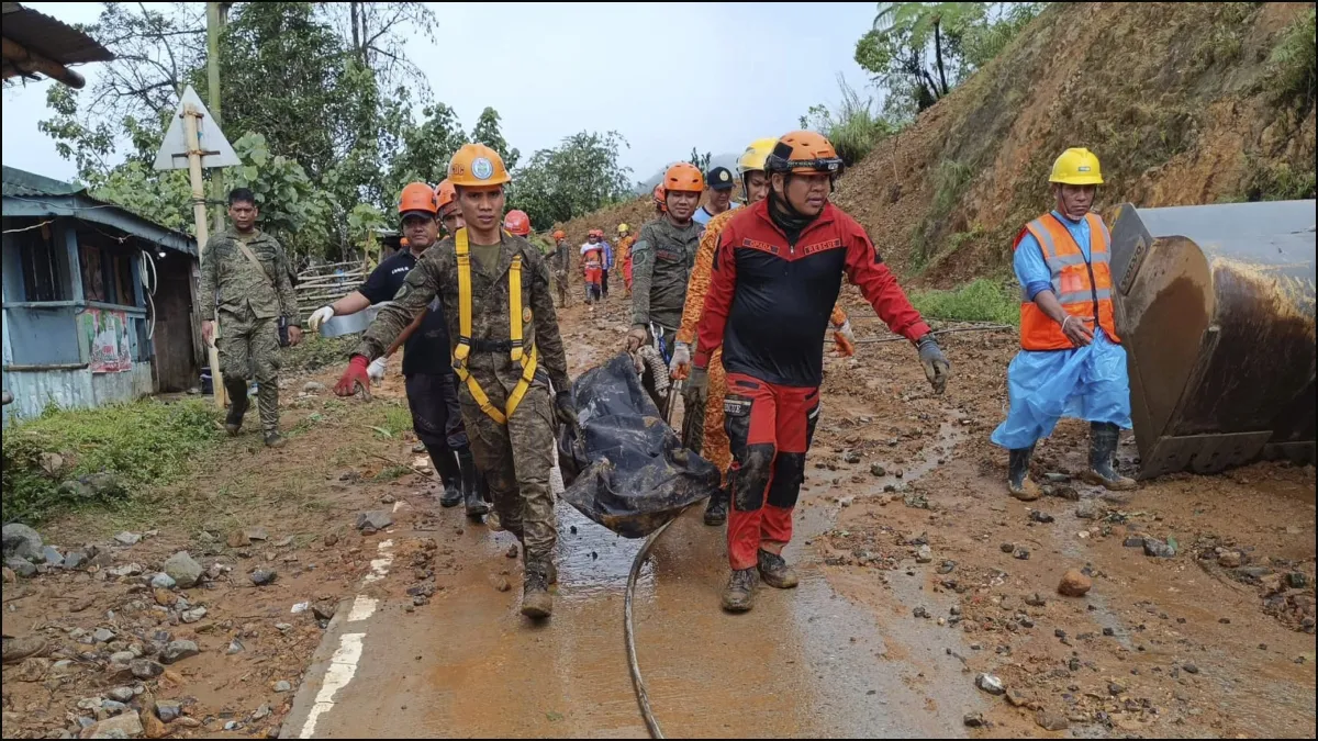Rescuers carry the body of one of the victims after the landslide in the Philippines