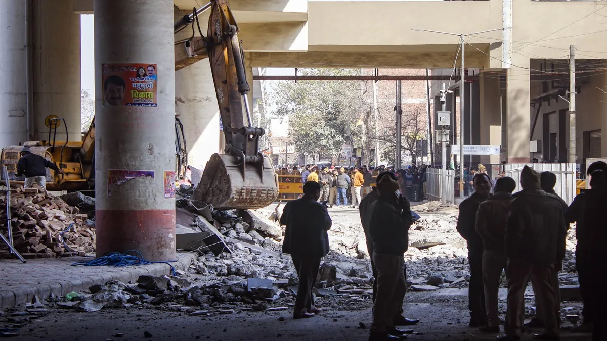 Officials stand near debris after portion of Gokulpuri Metro Station on Pink Line collapsed in New Delhi. 