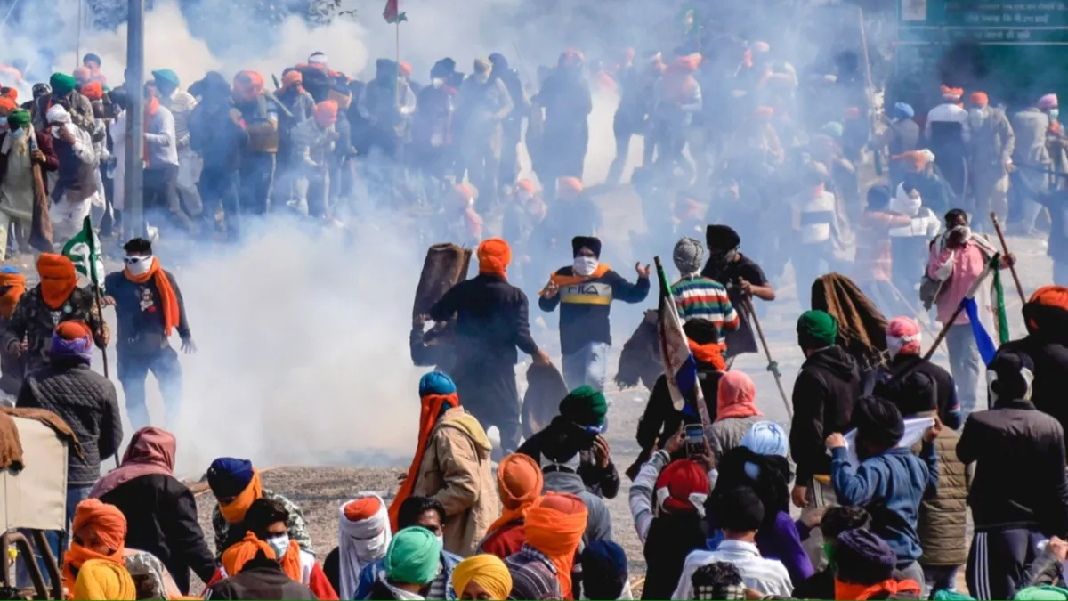 Farmers move away after police fired teargas shells to disperse them during their Delhi Chalo march at the Punjab-Haryana Shambhu border, near Patiala.