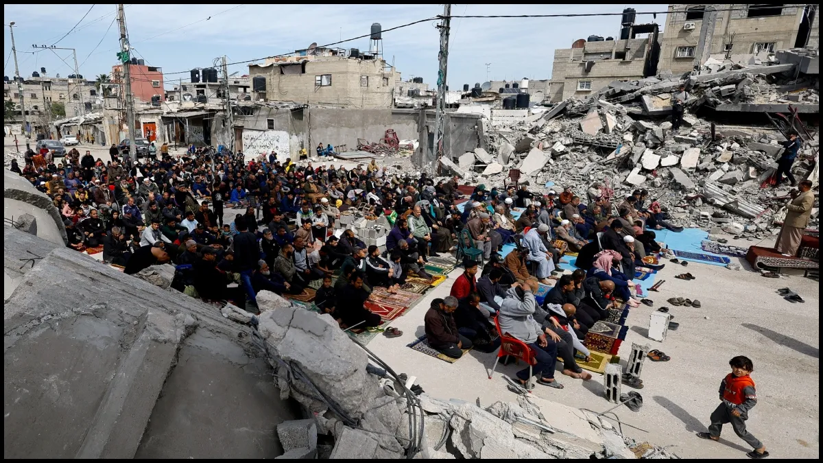 Palestinians attend Friday prayers near the ruins of a mosque destroyed in Israeli strikes.