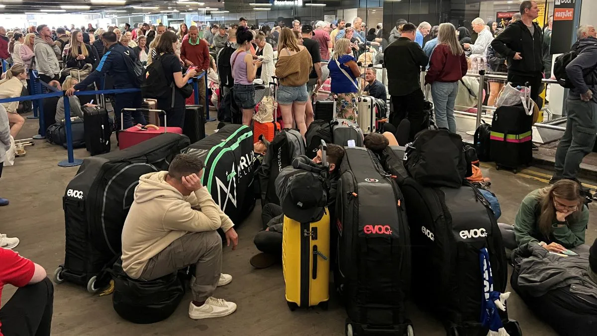 Passengers queue outside Terminal 1 after an overnight power cut led to disruptions and cancellations at Manchester Airport in Manchester
