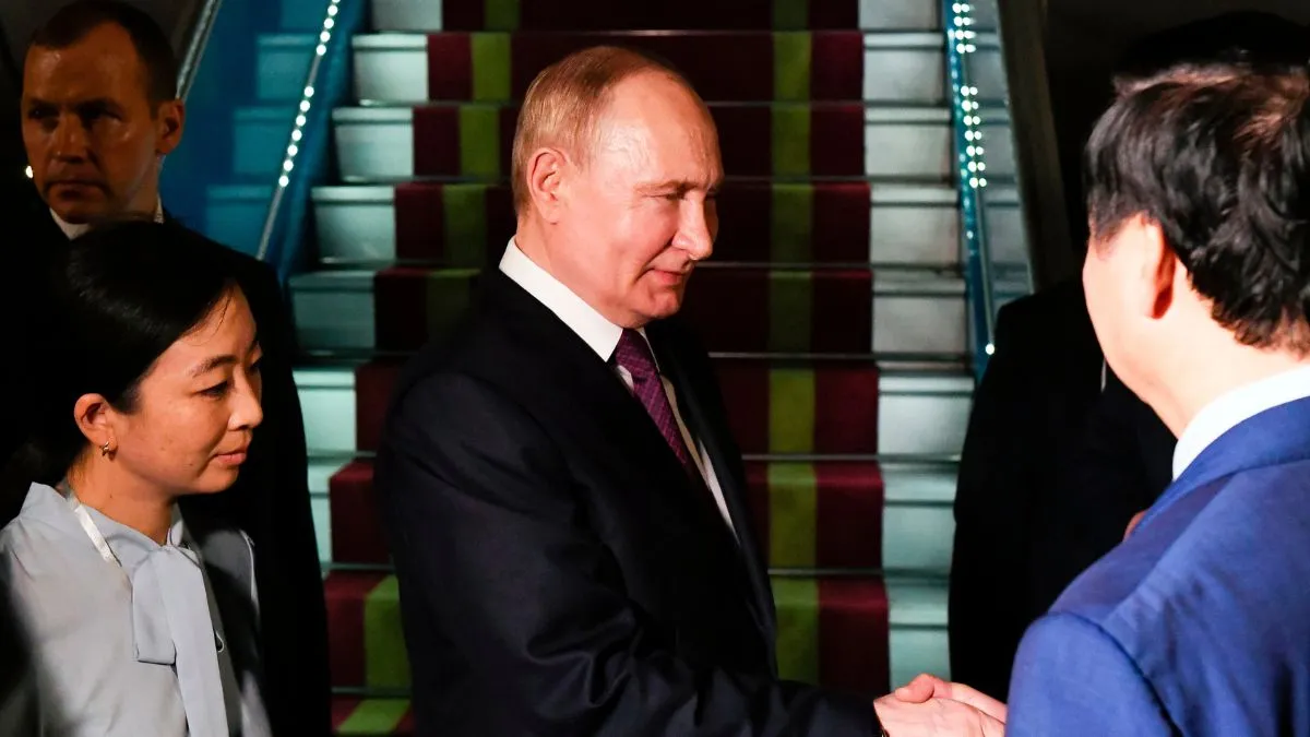 Russian President Vladimir Putin, second left, shakes hands with Vietnamese officials upon his arrival at Noi Bai International Airport in Hanoi