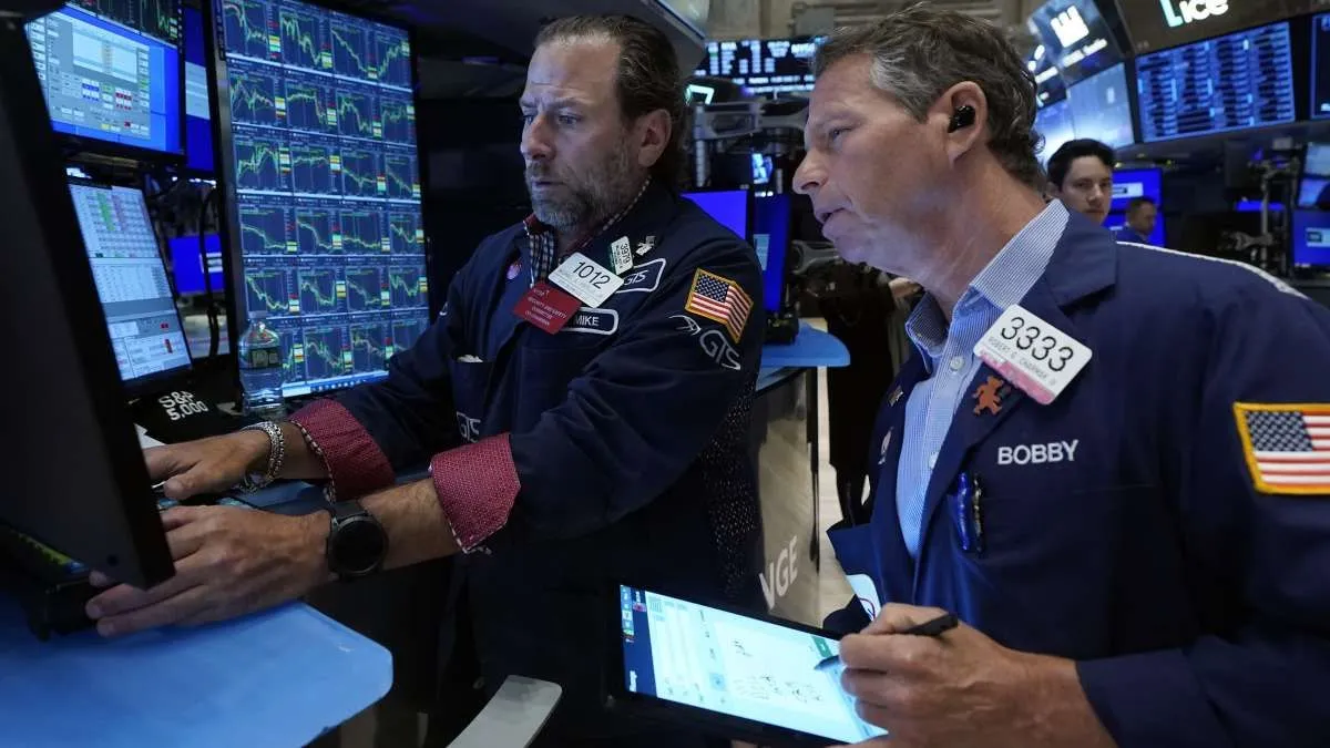 Specialist Michael Pistillo, left, and trader Robert Charmak work on the floor of the New York Stock Exchange
