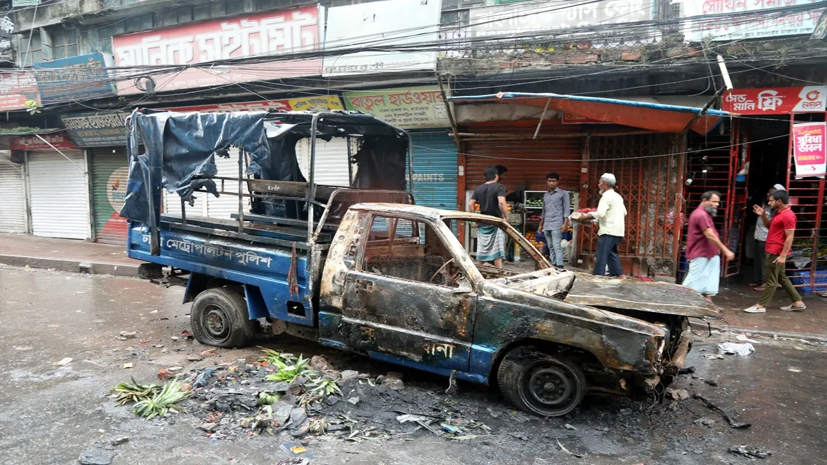  A burnt vehicle on the street following protests in Dhaka