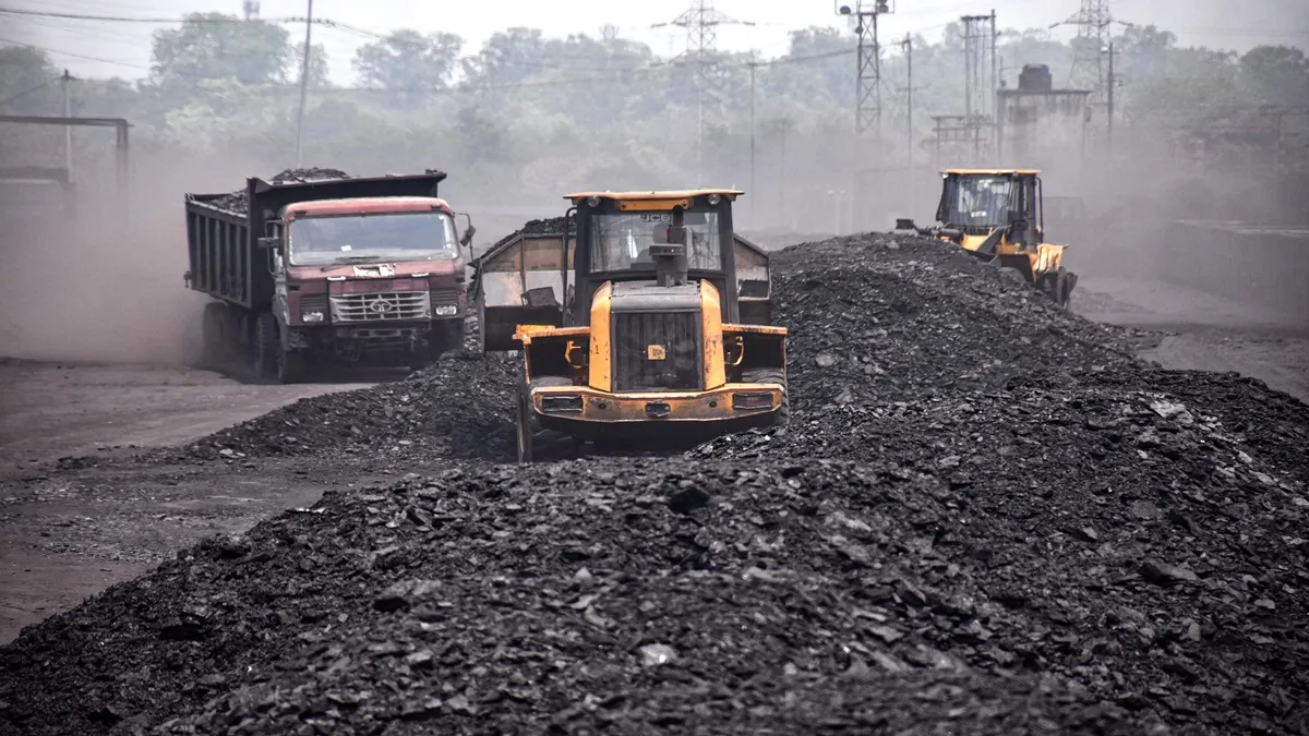 Labourers carry coal onto goods train at Ashoka Coal Mines in Peeparwar.