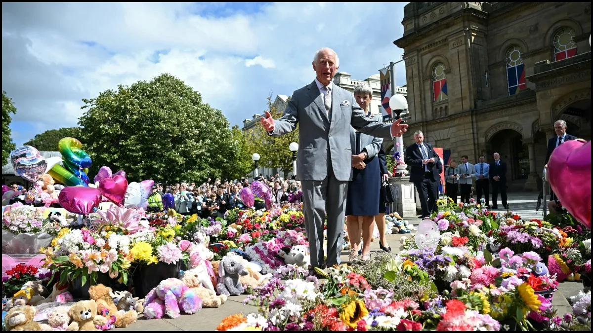 Britain's King Charles III reacts as he views tributes outside Southport Town Hall.