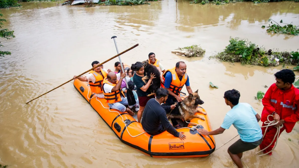Personnel from Tripura Disaster Management Authority evacuate people from a flood-affected area following heavy rainfall, on the outskirts of Agartala.