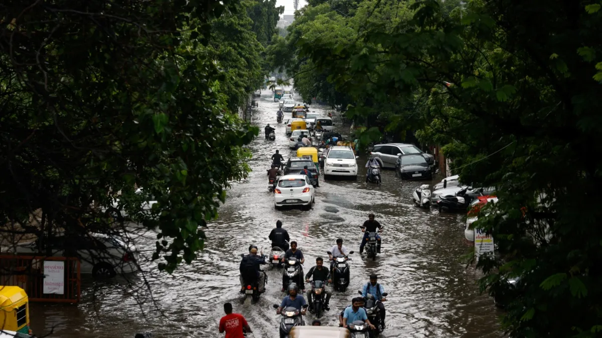Traffic moves through a flooded road after heavy rains.