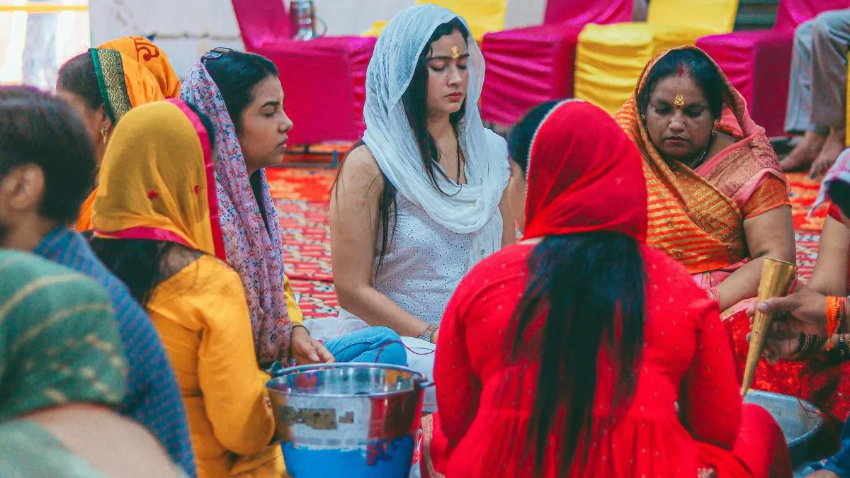 Devotees narrating and listening to the sacred Haratalika Teej story.