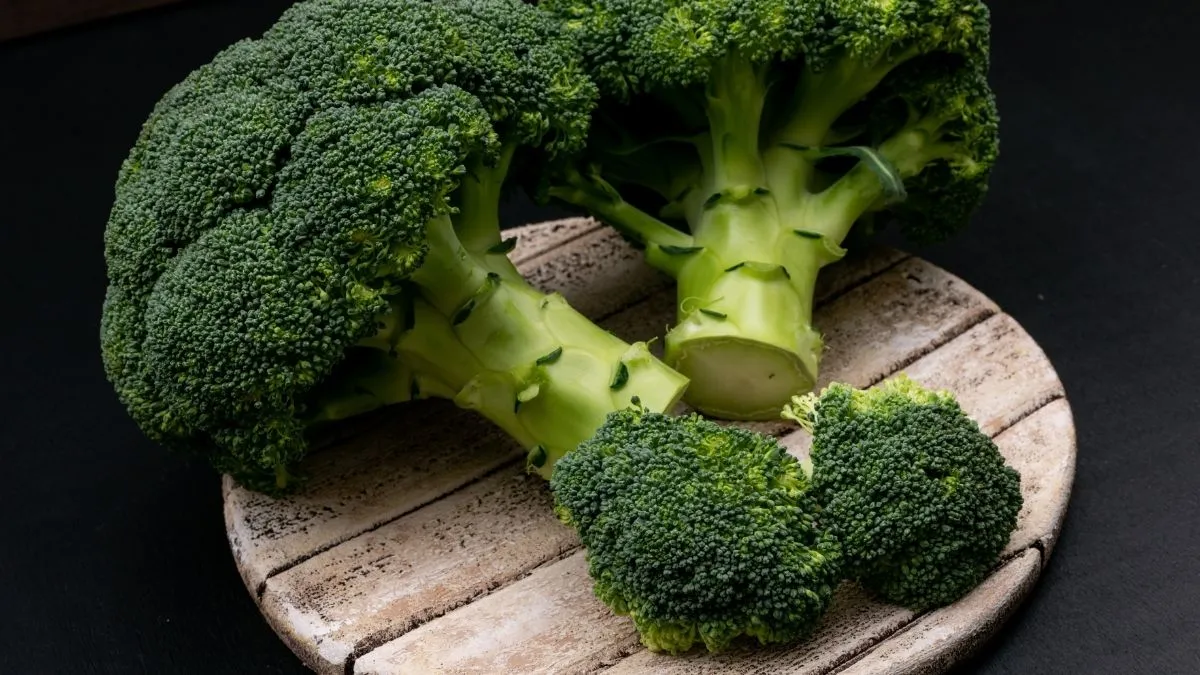 Fresh broccoli kept on a wooden board; the fibre-rich vegetable is often used to make light, healthy soups for weight loss.