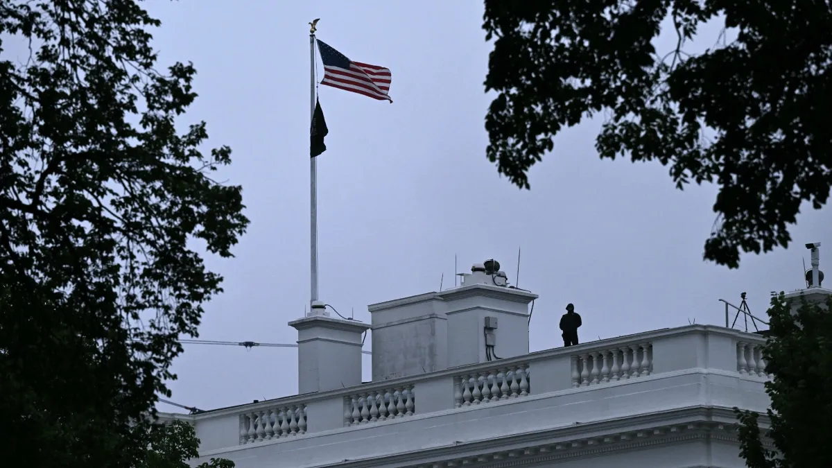 A police officer stands on the roof of a building at the White House. A police officer stands on the roof of a building at the White House.
