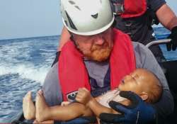 Rescuer carries dead body of 1-yr-old baby drowned in Mediterranean