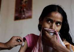 A nurse administers a shot to a tuberculosis patient in India