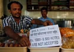 A man puts a notice inside his eatery in Mumbai.
