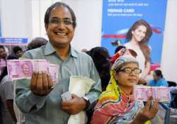 People show their fingers marked with ink after exchanging old currency