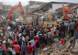 Rescuers search for victims under the rubble of collapsed buildings in Aceh