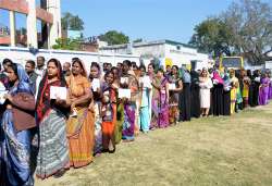 Women voters wait to cast their votes at a polling station in Faizabad