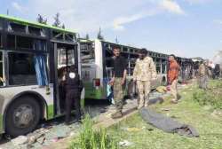 Rebel gunmen stand at the site of a blast