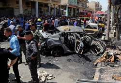 Security forces and civilians at the site of a deadly bomb attack in Baghd