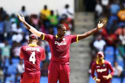 Jason Holder (C) celebrates after dismissing India's captain Virat Kohli