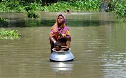 A woman with her child in flood affected Khanamukh village in Morigoan, Assam