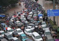 Vehicles stuck at a flooded street after heavy rains in Thane