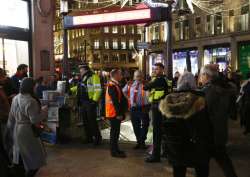 Police officers and Transport for London workers stand at the entrance of Oxford Circus subway station in the west of London after it was reopened on November 24, 2017.