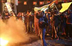 Palestinian protestors burn tires as they wave national flags during a protest at the main Square in Gaza City on December 6.