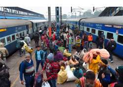 Passengers, wearing warm clothes, wait for their trains at New Delhi Railway Station.