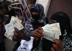 FILE - In this Nov. 14, 2015 file photo, women display paper currency after receiving cash support from UNICEF, in Sanaa, Yemen.