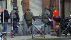 Belgium security personnel enter a building in Brussels in this image taken from TV Thursday Feb. 22, 2018. Belgian police have sealed off part of a Brussels suburb amid media reports that an armed man could be at large.