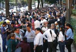 People stand along Reforma Avenue after a 7.2-magnitude earthquake shook Mexico City on Friday, February 16, 2018. 