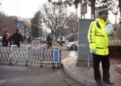 Chinese policemen stand guard at a road barricade in front of the Diaoyutai State Guesthouse in Beijing.