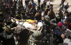 Fateh masked militants carry the body of Hamdan Abu Amsha, 23, during his funeral out side of the cemetery in Beit Hanoun, Gaza Strip