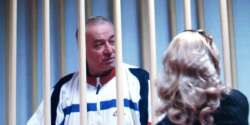 Sergei Skripal speaks to his lawyer from behind bars in a Moscow courtroom in 2006