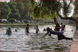 Children beat the heat in the waters at the India Gate Boat Club, as the mercury rises, in New Delhi on Saturday.