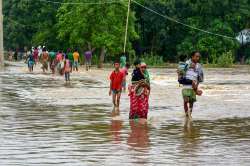 People shift to safer places from a flooded locality after heavy downpour, at Nam Doboka village in Hojai district of Assam.